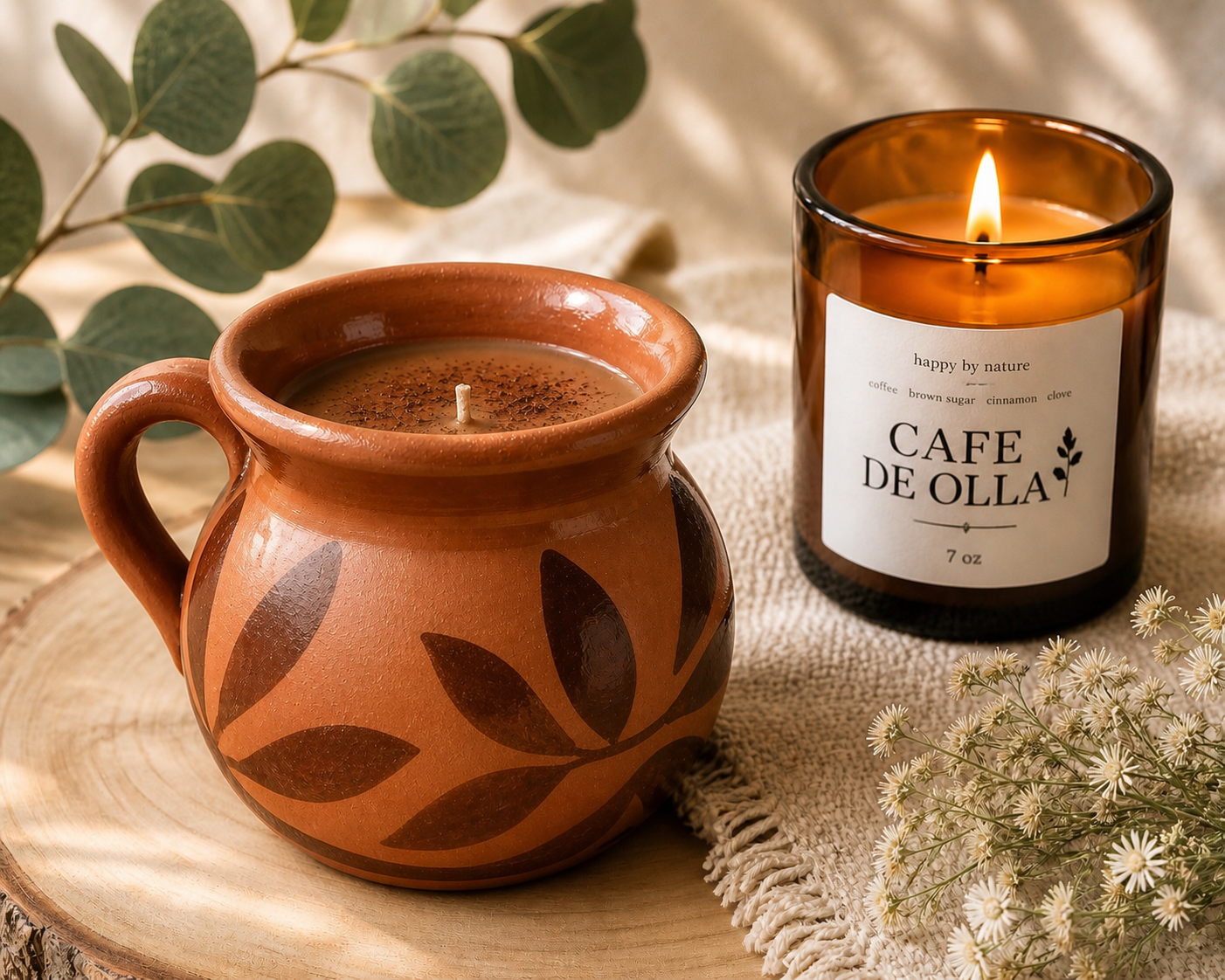 Cafe de Olla lit beside a clay mug and eucalyptus